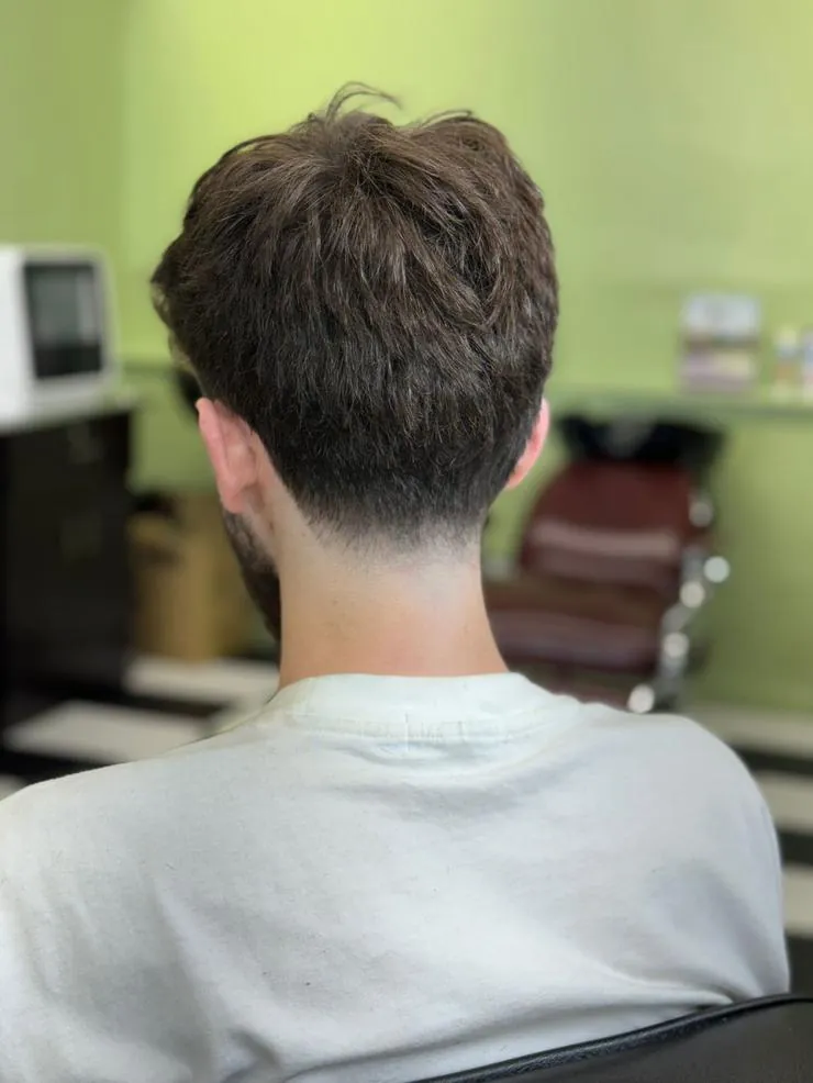 Back view of a short textured haircut with a tapered neckline