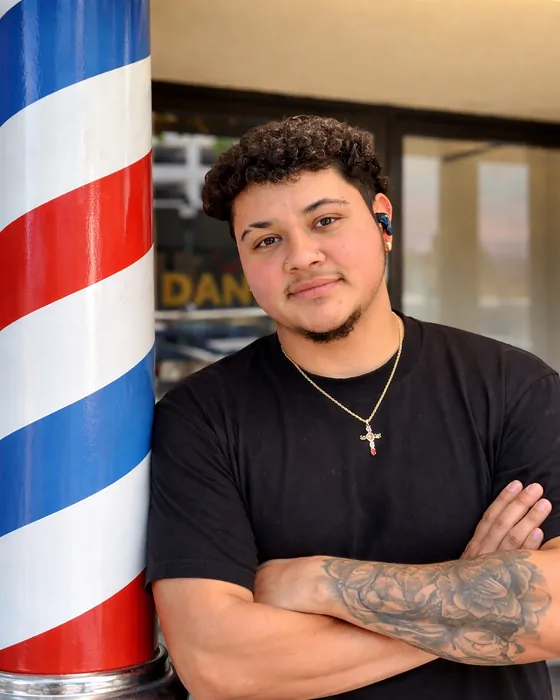 Gael Verdusco, barber at Dandies, standing by the barber pole