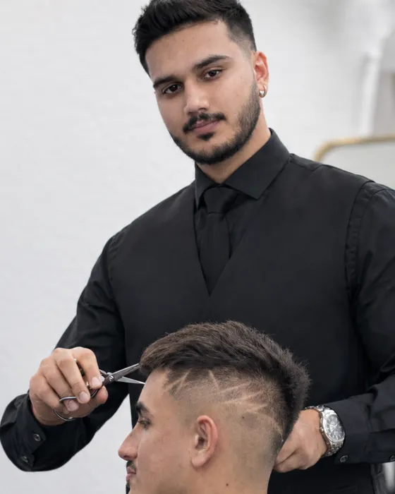Preet Singh, barber at Dandies Sunnyvale, cutting a client's hair with shears